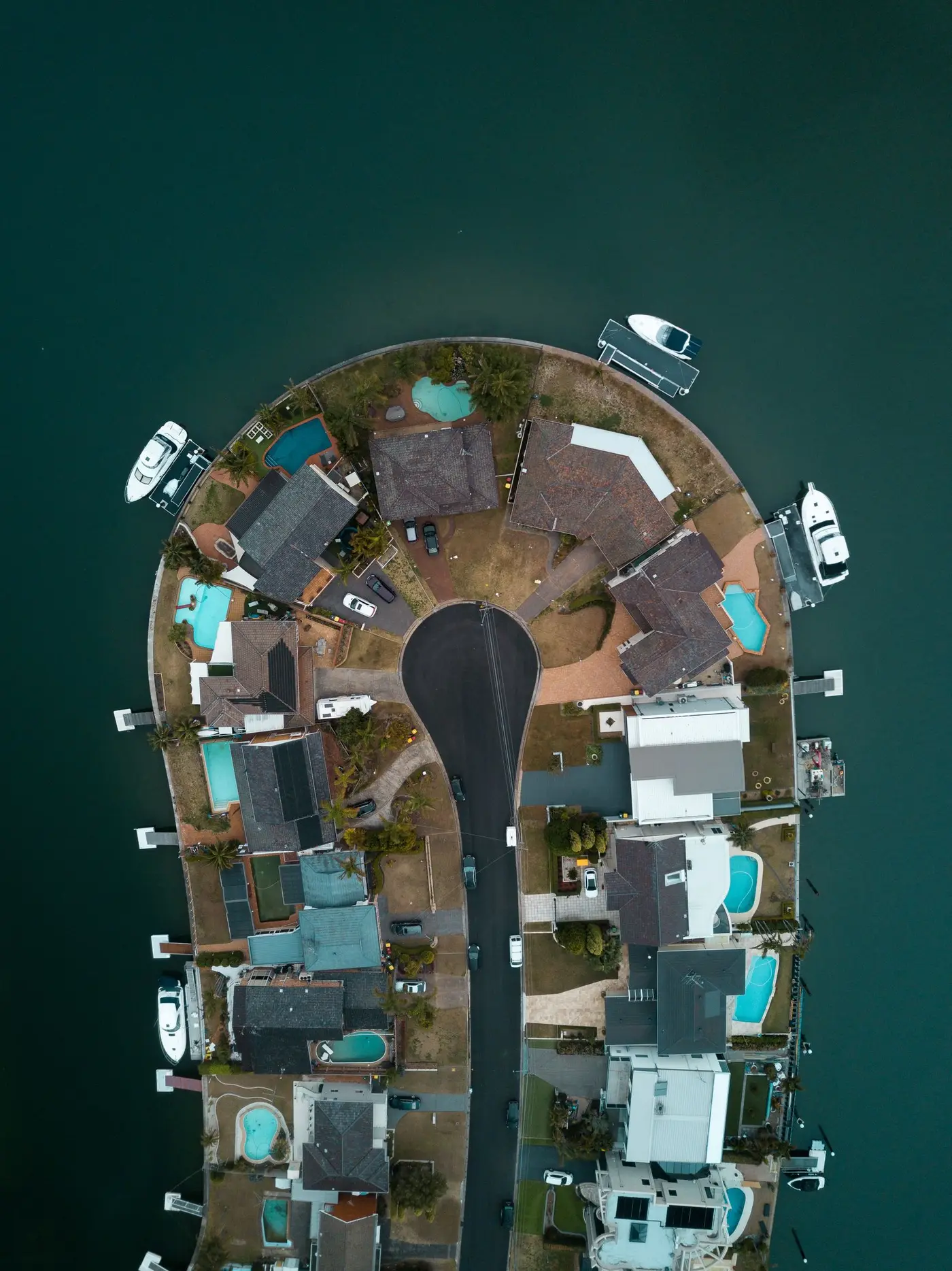 Top-down aerial of Australian waterfront homes, nearly every backyard with a pool