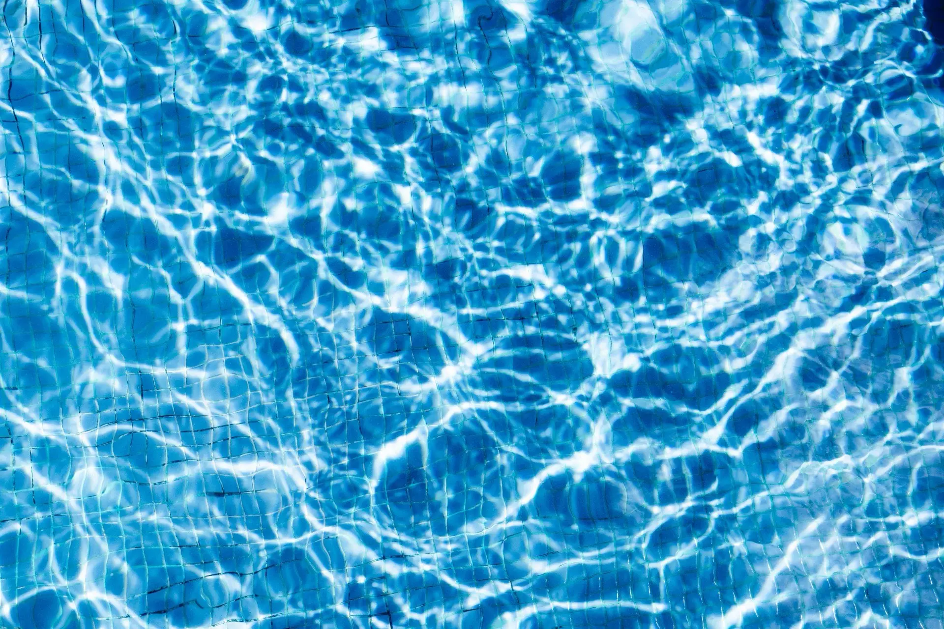 Sunlit ripples across clear blue pool water